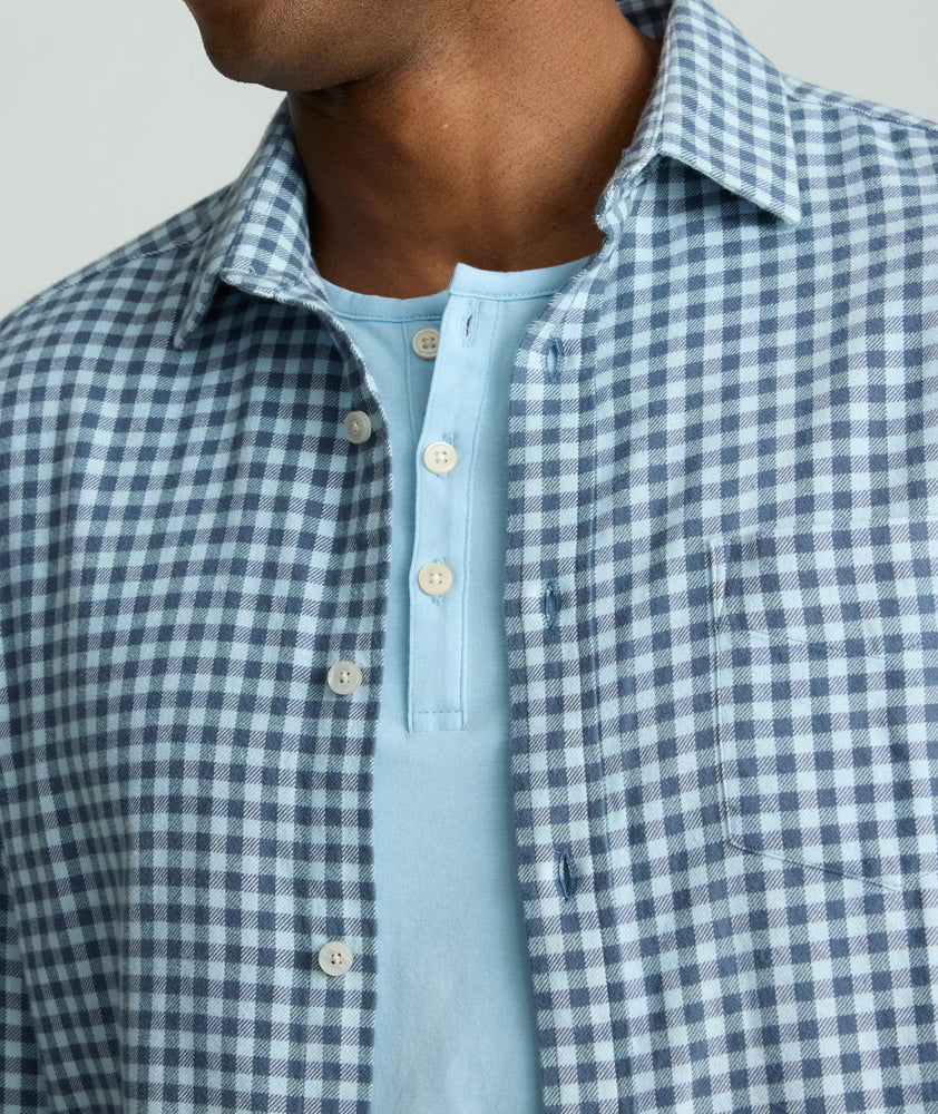 Model is wearing an UNTUCKit Alden gingham shirt in light blue.