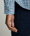 Model is wearing an UNTUCKit Alden gingham shirt in light blue.