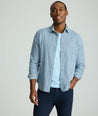 Model is wearing an UNTUCKit Alden gingham shirt in light blue.