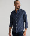 Model is wearing UNTUCKit Armstrong shirt in dark blue check.