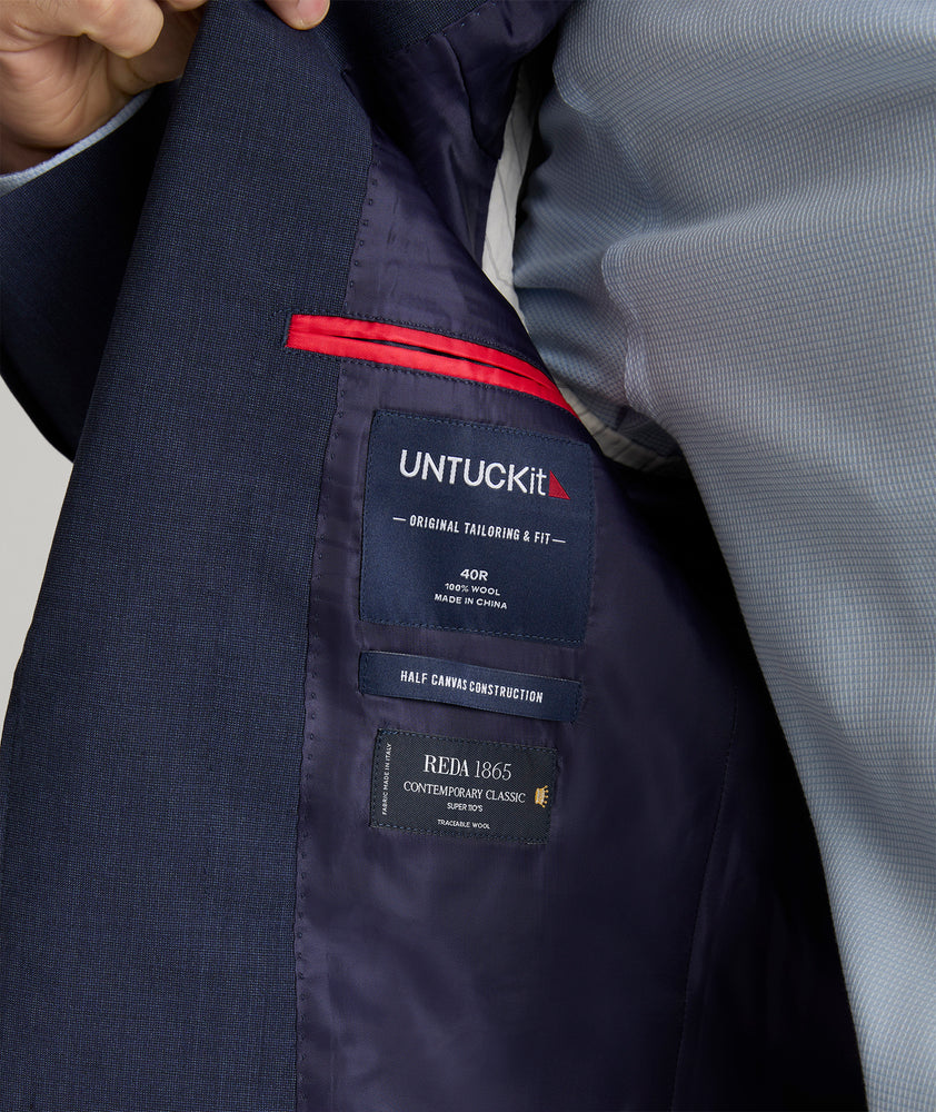 Model is wearing UNTUCKit Beasley sport coat in navy.