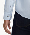 Model is wearing UNTUCKit Wrinkle-Free Burke Shirt in Textured Blue Chambray with Contrast Cuff.
