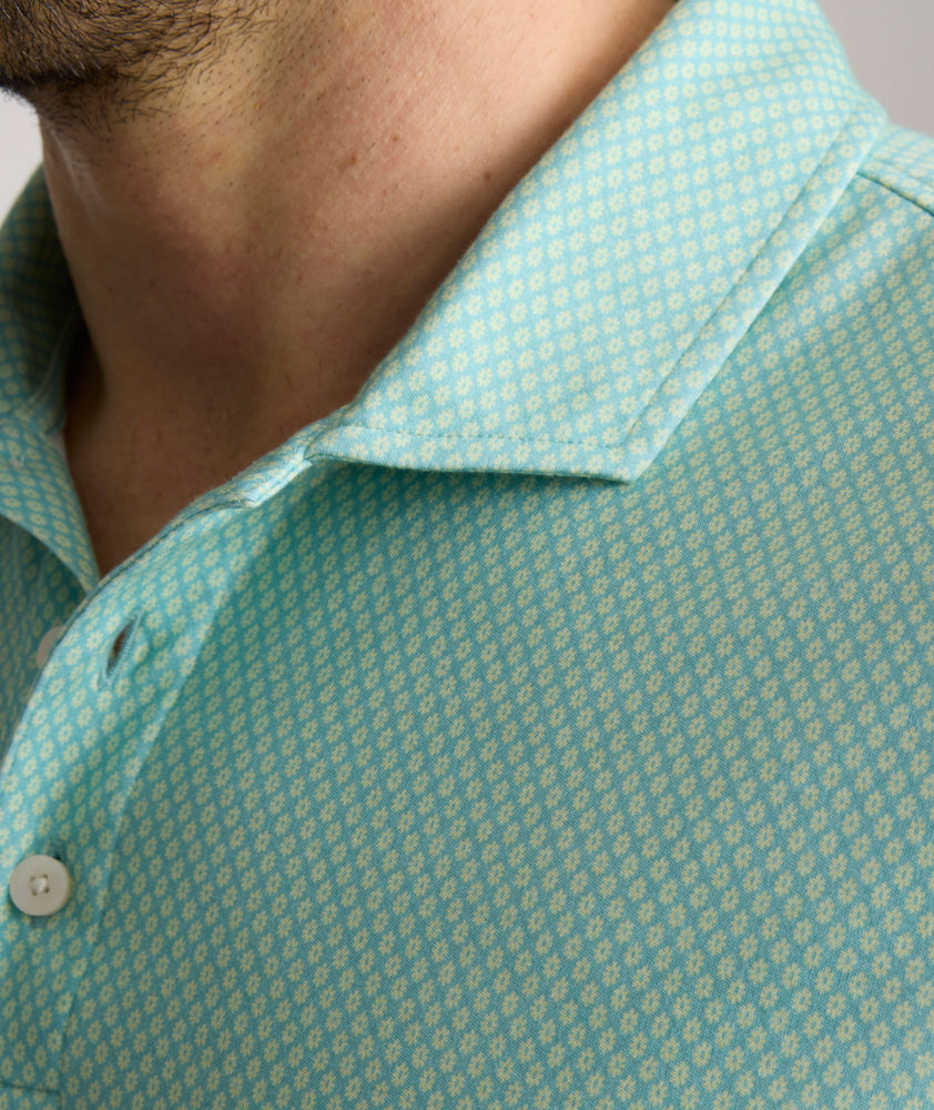 Model is wearing UNTUCKit Chen wrinkle free polo in bright green foulard print.