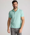 Model is wearing UNTUCKit Chen wrinkle free polo in bright green foulard print.