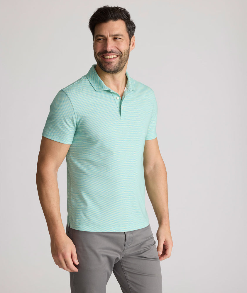 Model is wearing UNTUCKit Chen wrinkle free polo in bright green foulard print.