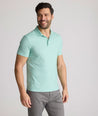 Model is wearing UNTUCKit Chen wrinkle free polo in bright green foulard print.