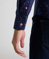 Model is wearing UNTUCKit Kipling shirt in navy with white and red triangles.