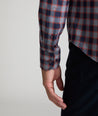 Model is wearing UNTUCKit Watkins shirt in grey, red and navy check.
