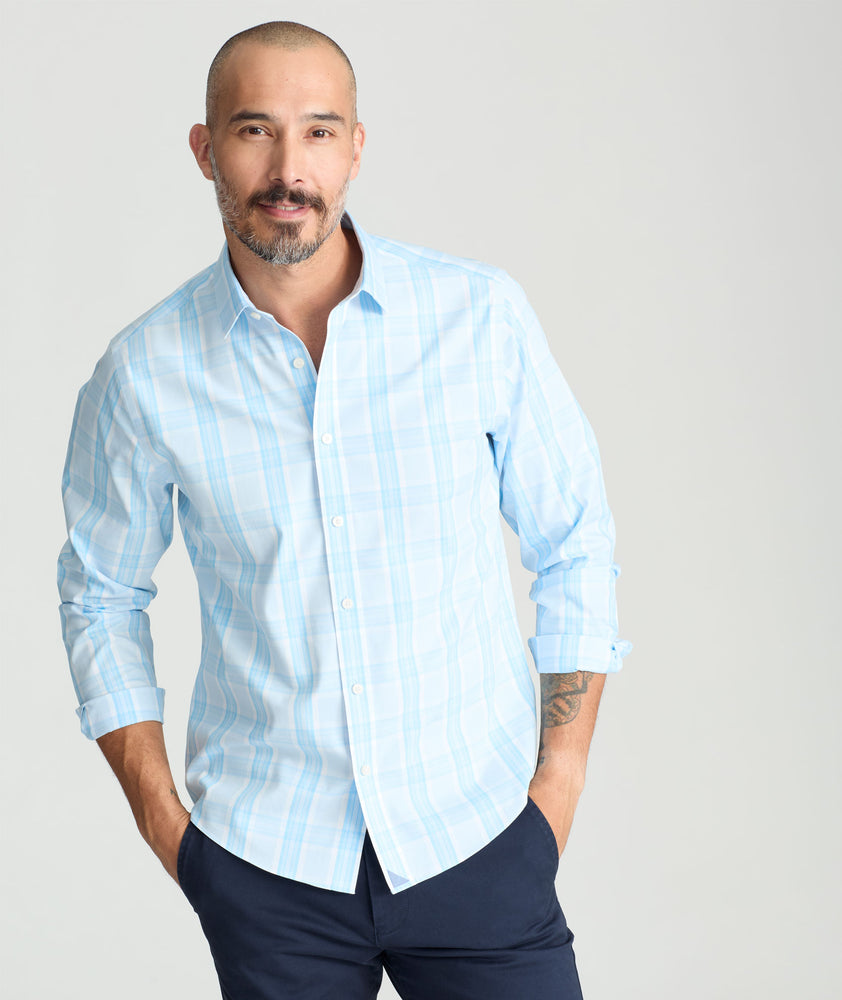Model is wearing UNTUCKit yates wrinkle-free shirt in light blue large plaid.