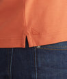Model is wearing UNTUCKit orange Tipped Johnny Collar Polo.