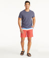 Model wearing UNTUCKit Mid Red 7-Inch Recycled Swim Trunks