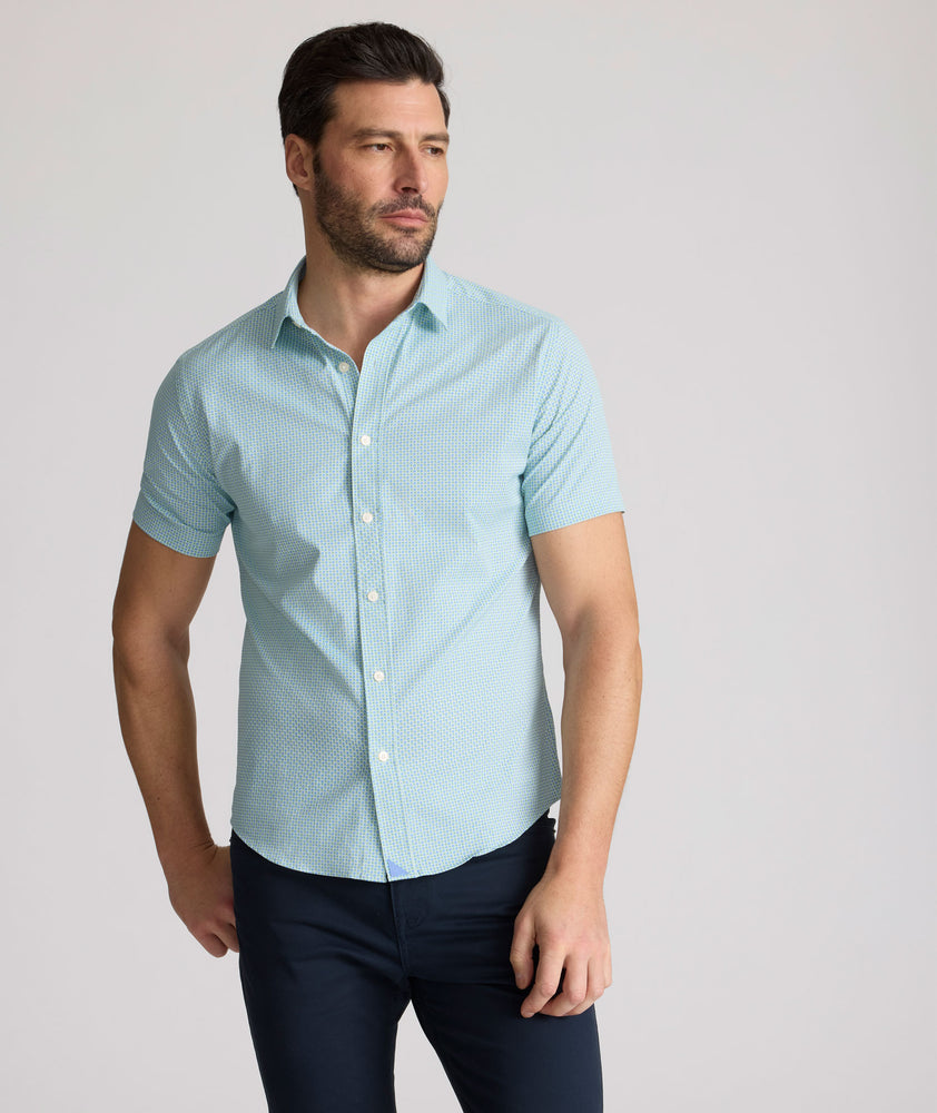 Model is wearing UNTUCKit Ackerman shirt in green ditsy floral print. 