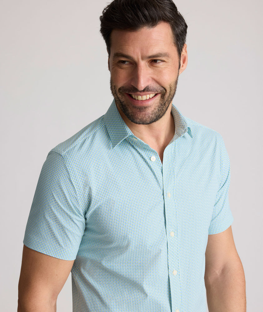 Model is wearing UNTUCKit Ackerman shirt in green ditsy floral print. 