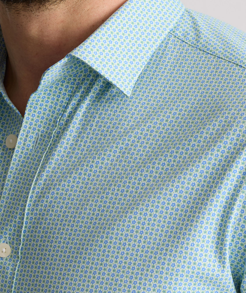 Model is wearing UNTUCKit Ackerman shirt in green ditsy floral print. 