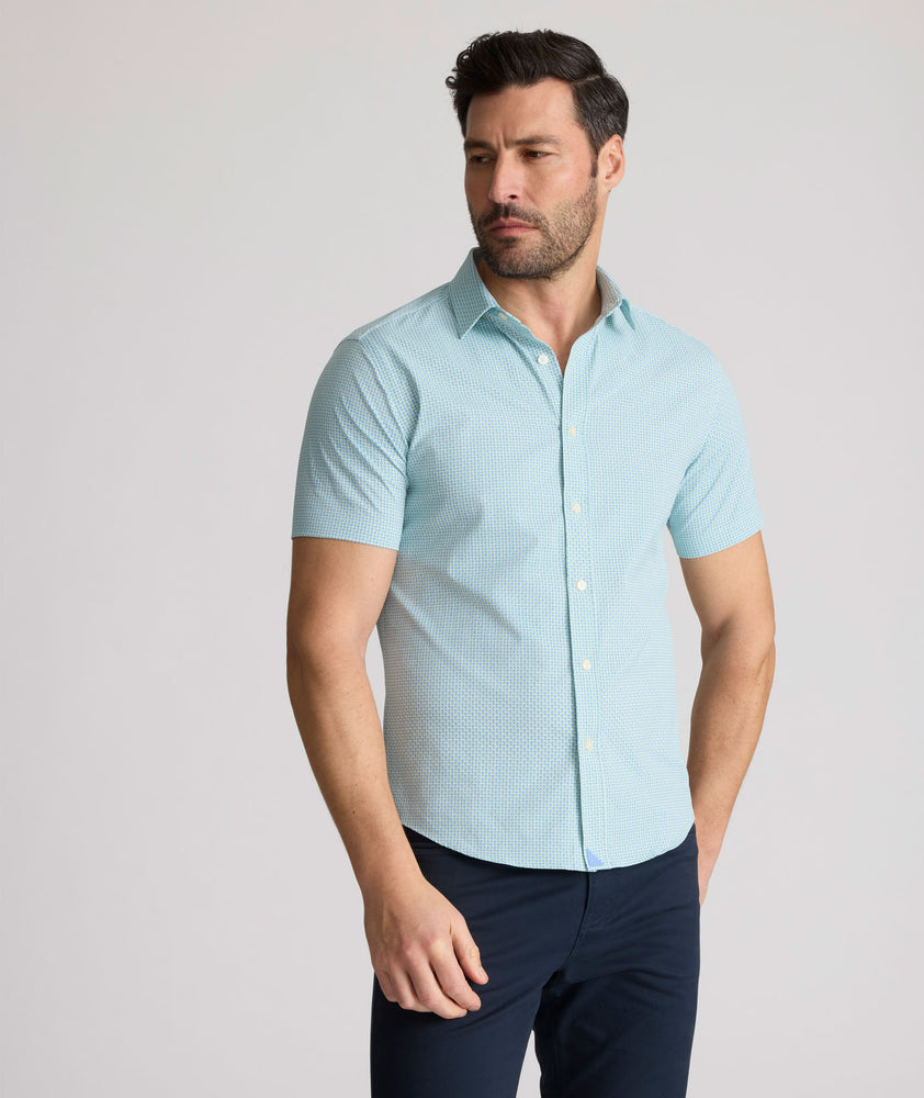Model is wearing UNTUCKit Ackerman shirt in green ditsy floral print. 