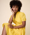 Model is wearing UNTUCKit solid Yellow Augusta Dress.