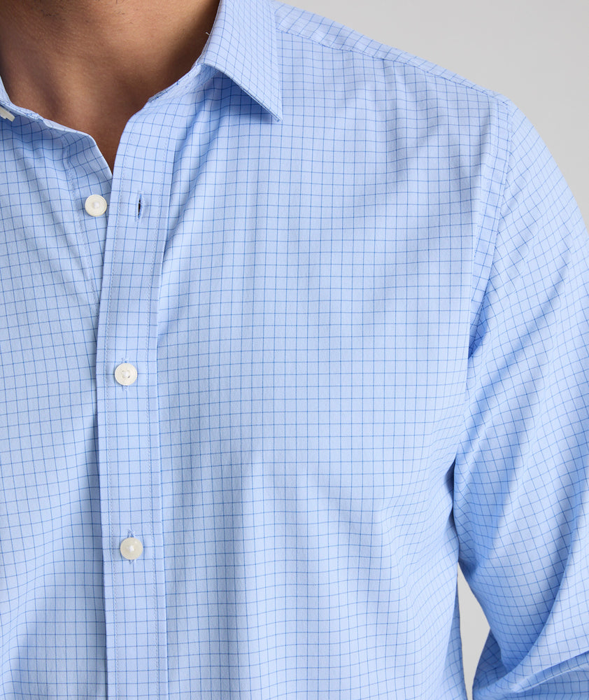 Model is wearing UNTUCKit Austin long sleeve performance shirt in light blue check. 
