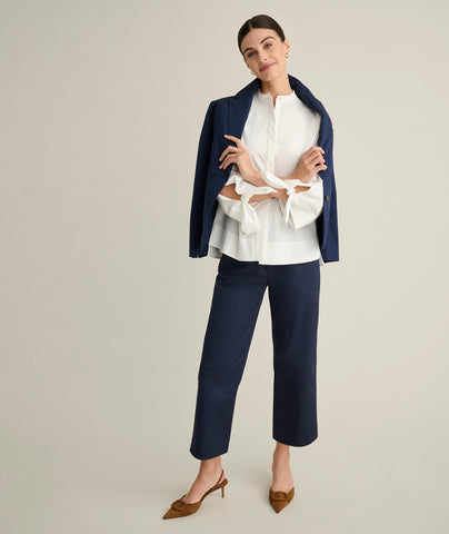 Model is wearing UNTUCKit Ava trousers in navy. 