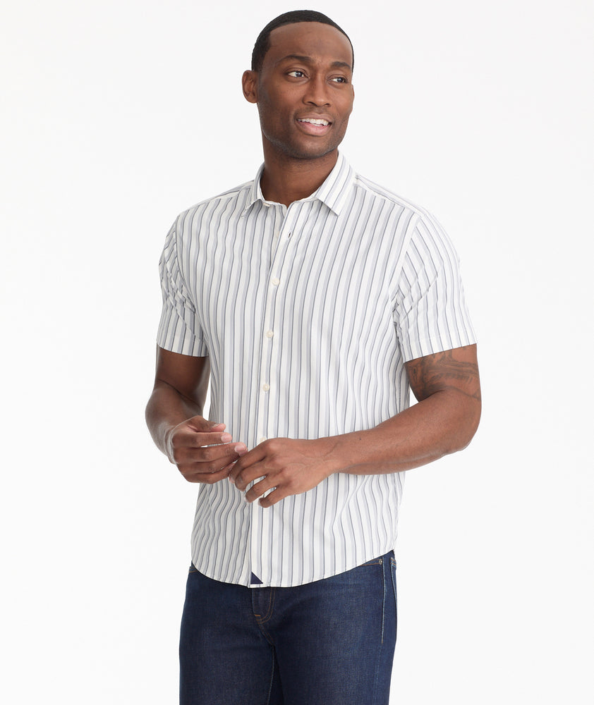 Model is wearing UNTUCKit Navy Stripe Wrinkle-Free Performance Short-Sleeve Bauman Shirt.