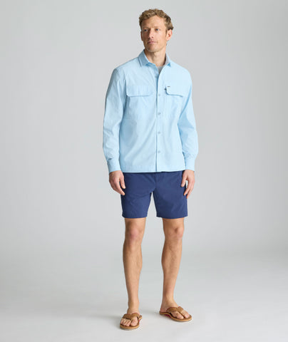 Model is wearing UNTUCKit Performance Fishing Shirt in light blue. 