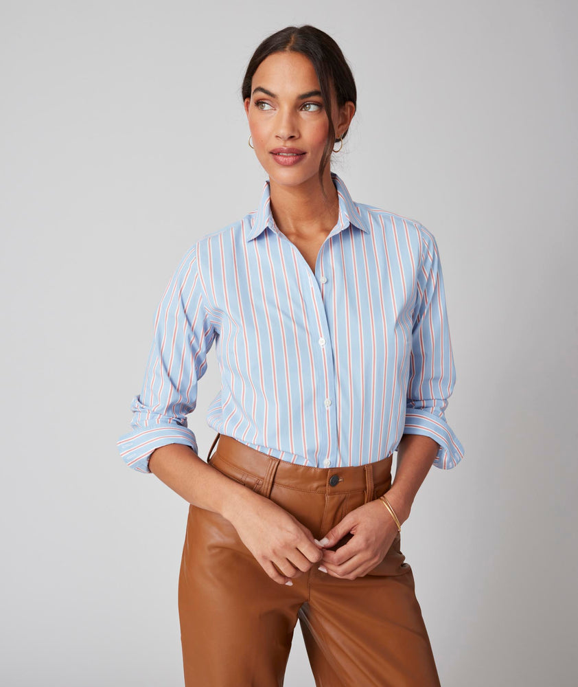Model is wearing UNTUCKit Bella shirt in light blue multi stripe.