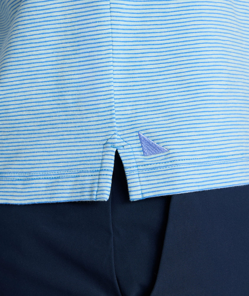 Model is wearing UNTUCKit Belvoir polo on blue aqua.