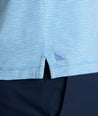 Model is wearing UNTUCKit Belvoir polo on blue aqua.