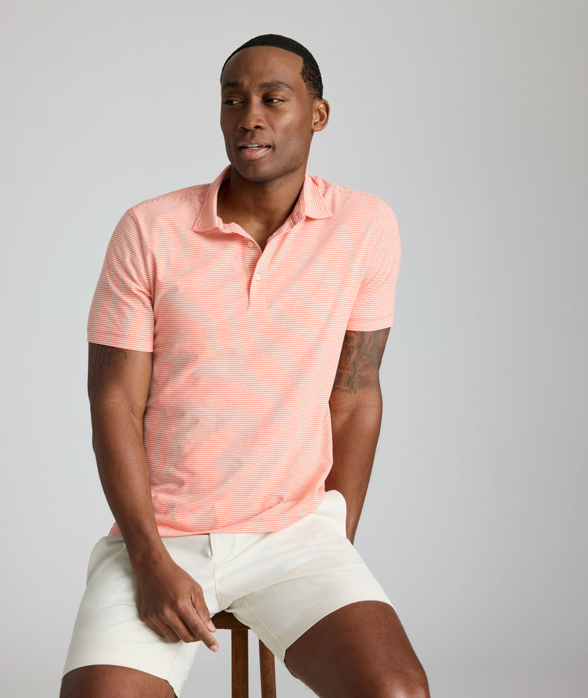 Model is wearing UNTUCKit Belvoir polo in emberglow. 