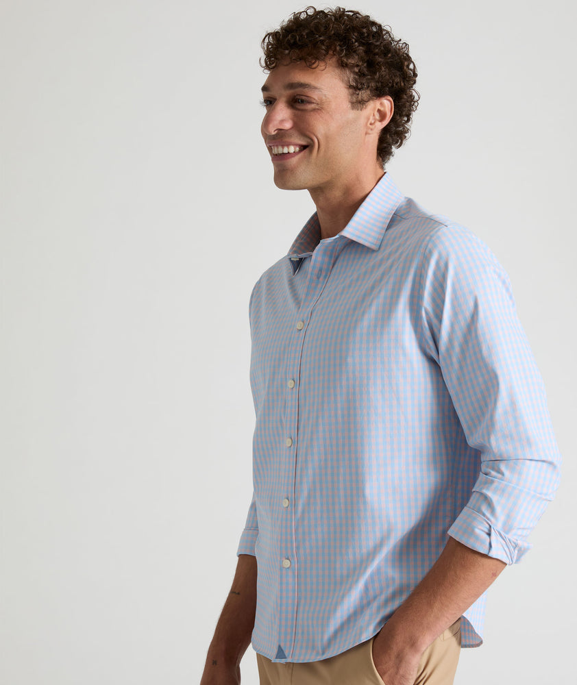 Model is wearing UNTUCKit Benson shirt in pink and blue gingham. 