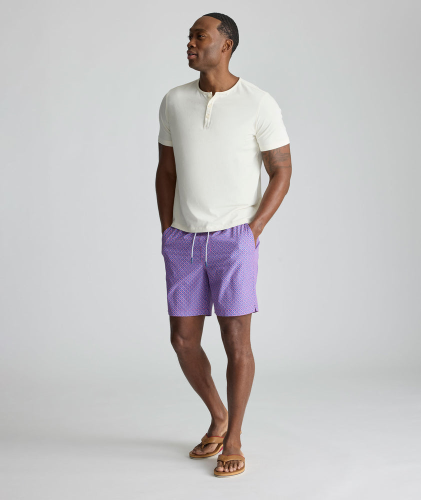 Model is wearing UNTUCKit Beyond Shorts in red and blue. 