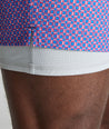 Model is wearing UNTUCKit Beyond Shorts in red and blue. 