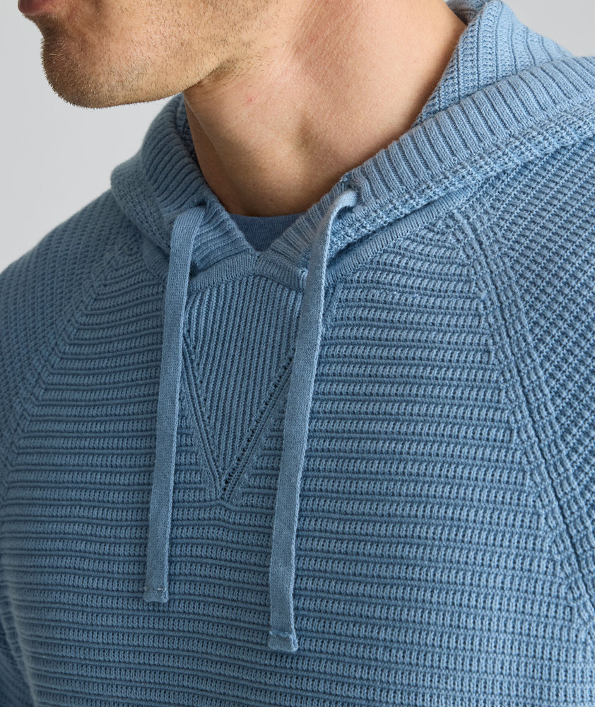 Model is wearing UNTUCKit Waffle-Knit Hoodie Sweater in blue. 