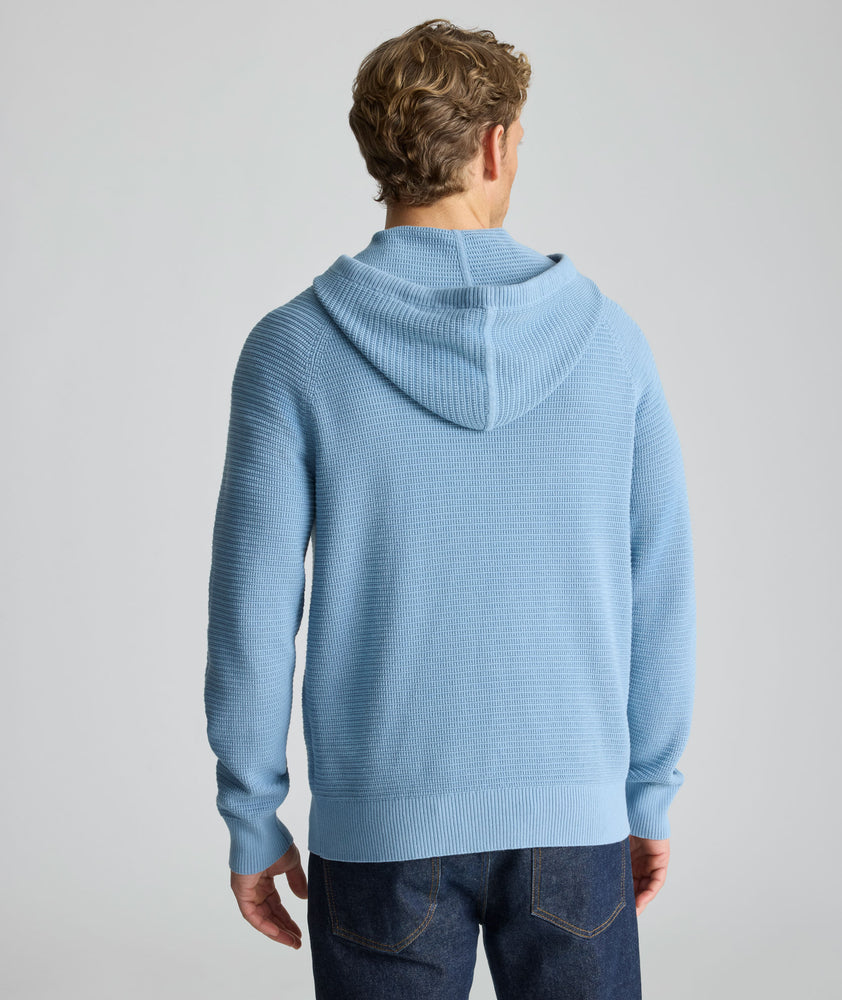 Model is wearing UNTUCKit Waffle-Knit Hoodie Sweater in blue. 