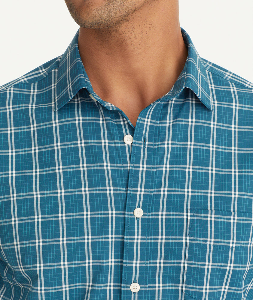 Model is wearing UNTUCKit Wrinkle-Free Performance Bolton Shirt in Teal & White Windowpane Check.