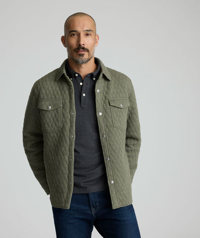 Model is wearing UNTUCKit Braunfield shirt jacket in beetle. 