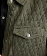 Model is wearing UNTUCKit Braunfield shirt jacket in beetle. 