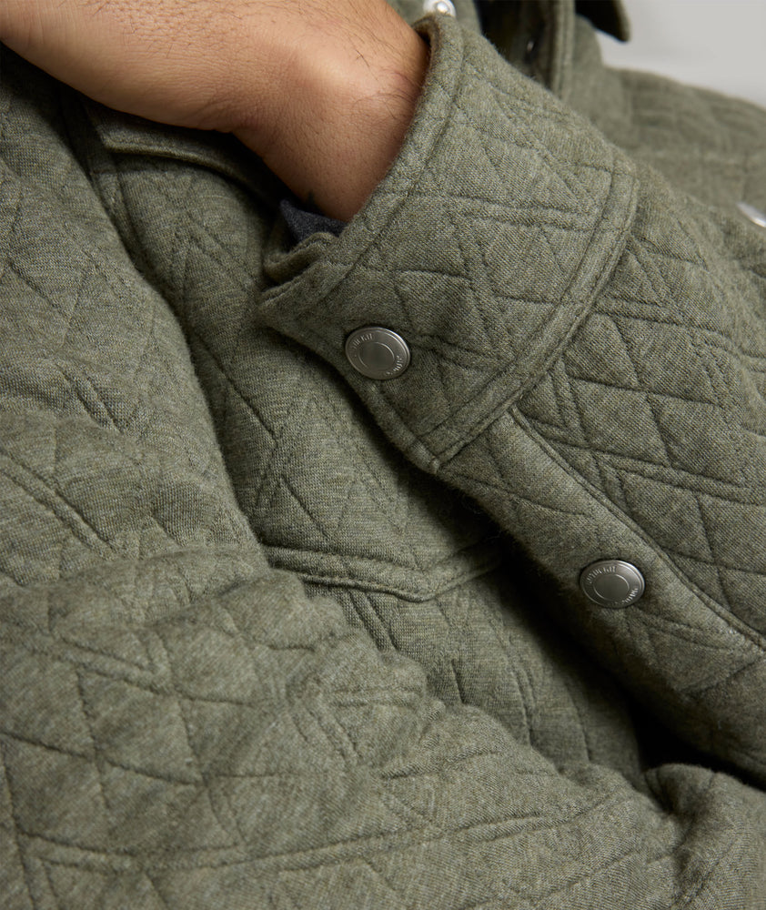 Model is wearing UNTUCKit Braunfield shirt jacket in beetle. 