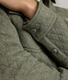 Model is wearing UNTUCKit Braunfield shirt jacket in beetle. 