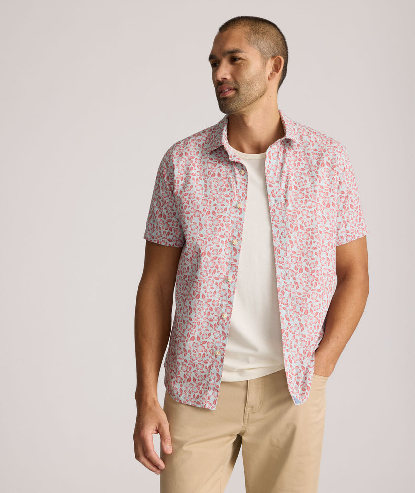 Model is wearing UNTUCKit buchanan short sleeve shirt in blue and rust floral. 