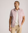 Model is wearing UNTUCKit buchanan short sleeve shirt in blue and rust floral. 