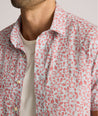 Model is wearing UNTUCKit buchanan short sleeve shirt in blue and rust floral. 