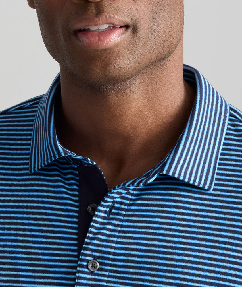 Model is wearing UNTUCKit Wrinkle-Free Damaschino Long-Sleeve Polo in Steel Blue Stripe. 