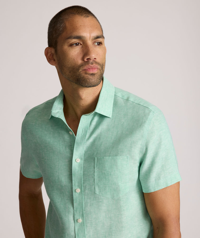 Model is wearing UNTUCKit solid ming green cameron shirt. 