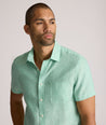 Model is wearing UNTUCKit solid ming green cameron shirt. 