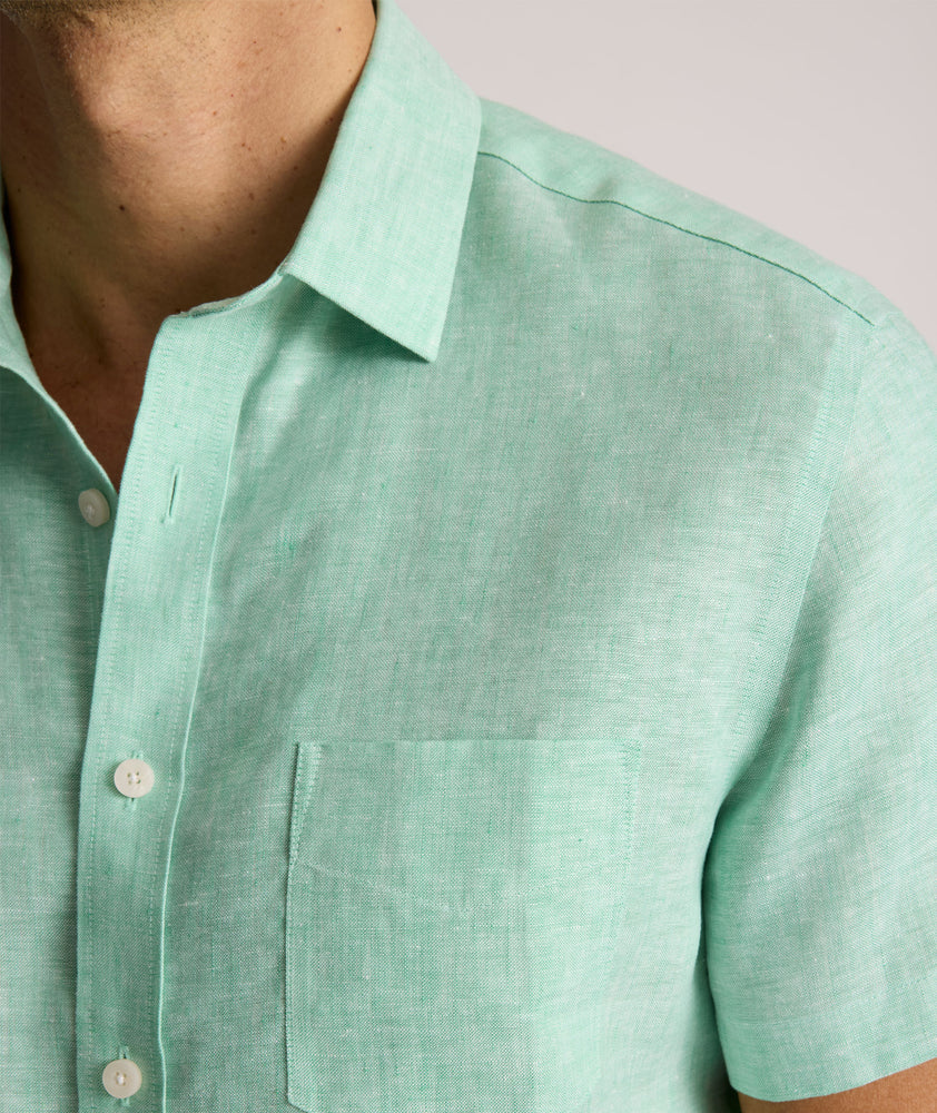 Model is wearing UNTUCKit solid ming green cameron shirt. 