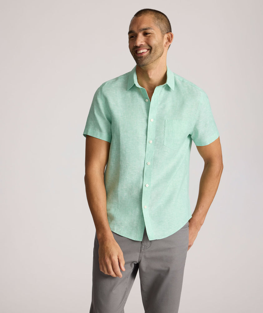 Model is wearing UNTUCKit solid ming green cameron shirt. 