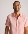 Model is wearing UNTUCKit solid coral haze cameron shirt. 