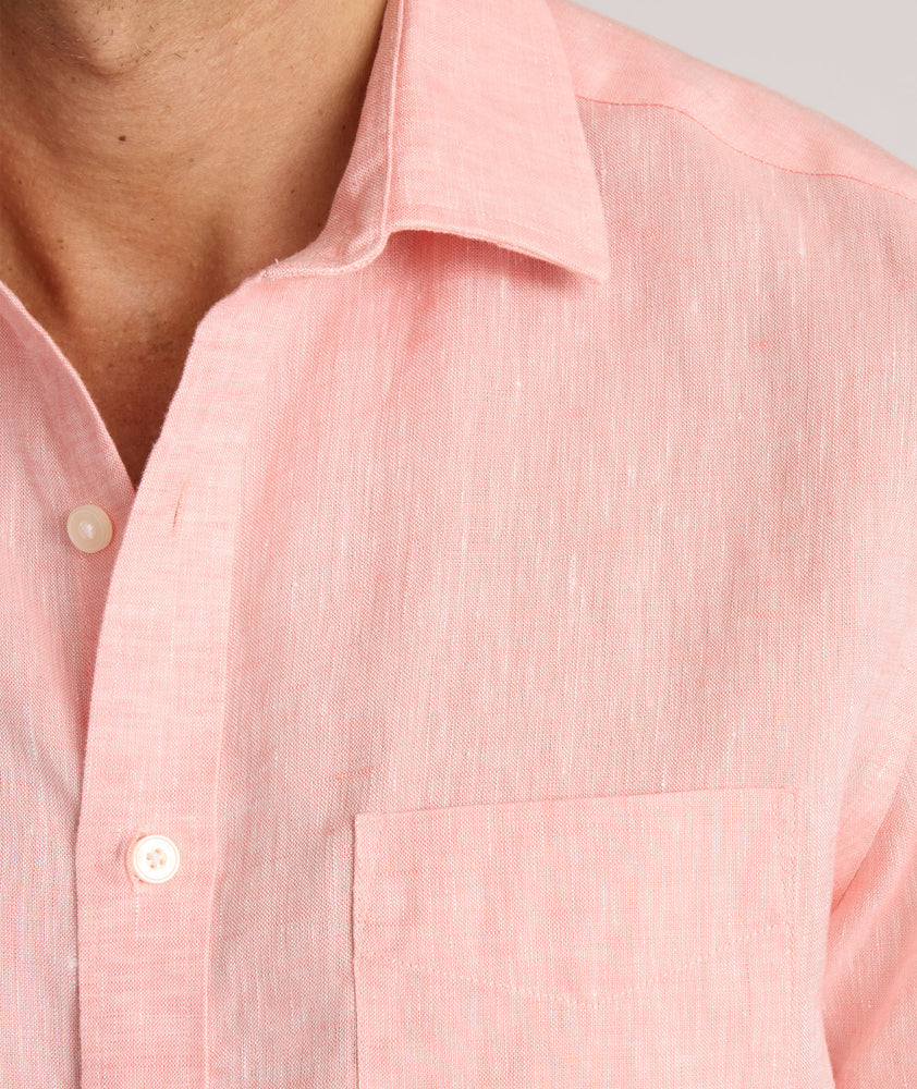 Model is wearing UNTUCKit solid coral haze cameron shirt. 
