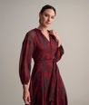 Model is wearing UNTUCKit Carly printed red dress. 