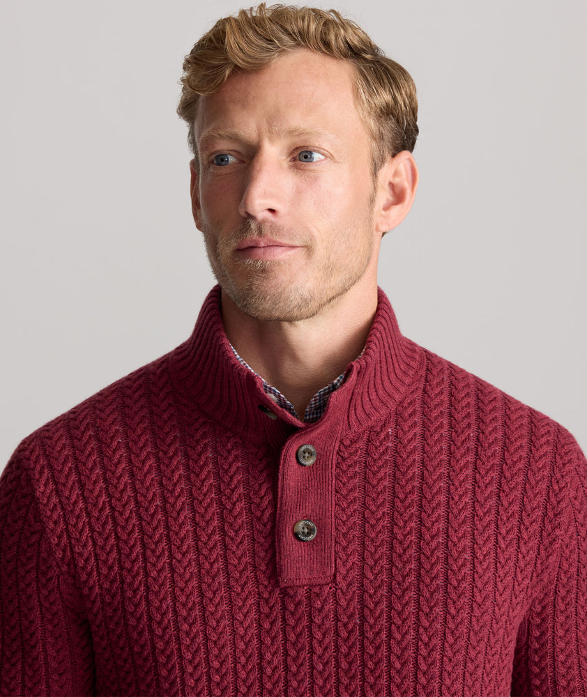 Model is wearing UNTUCKit Cable-Knit Button Neck Sweater in red. 